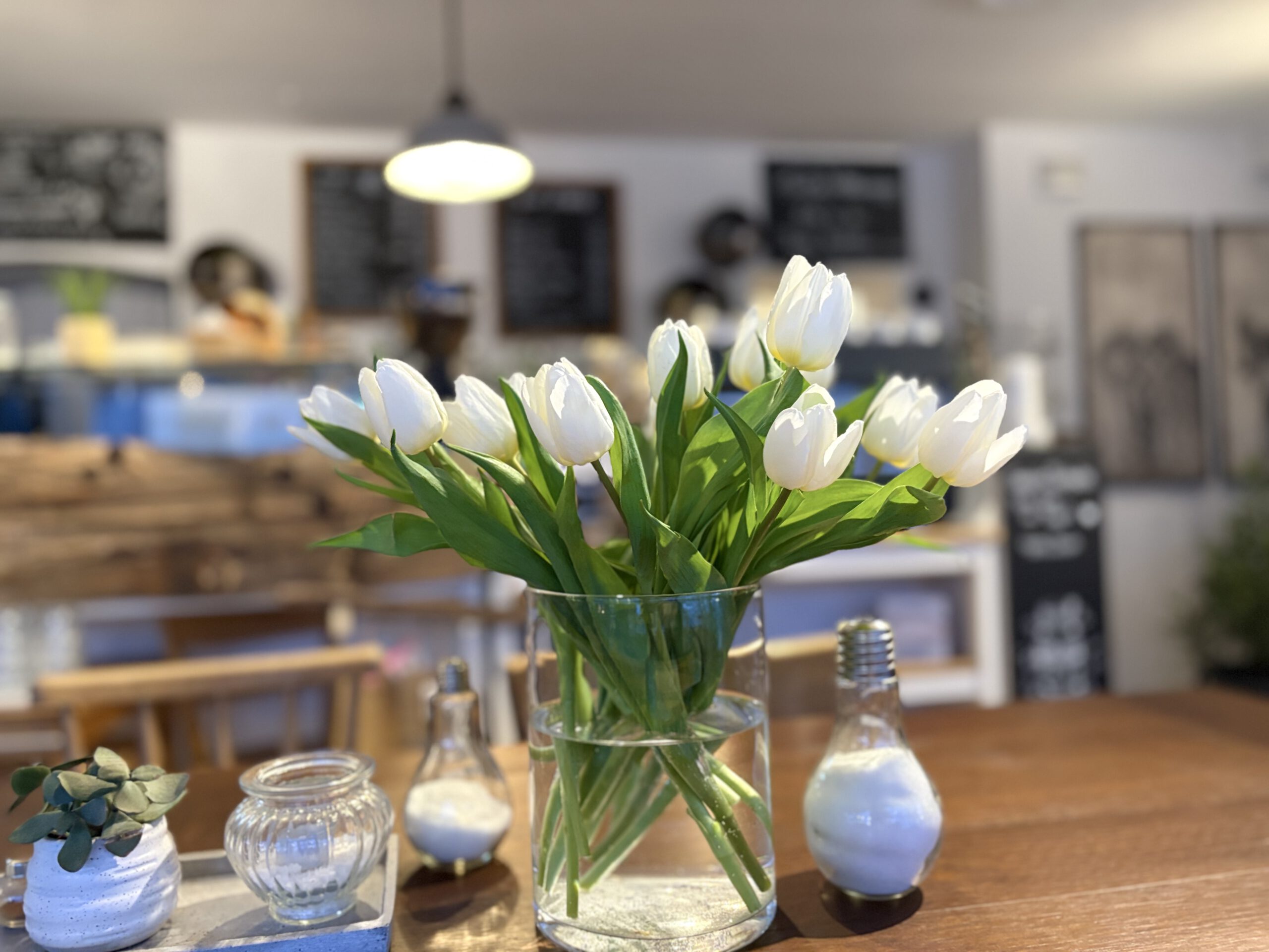 Weiße Tulpen auf Tisch im Wie_belle_art Cafe